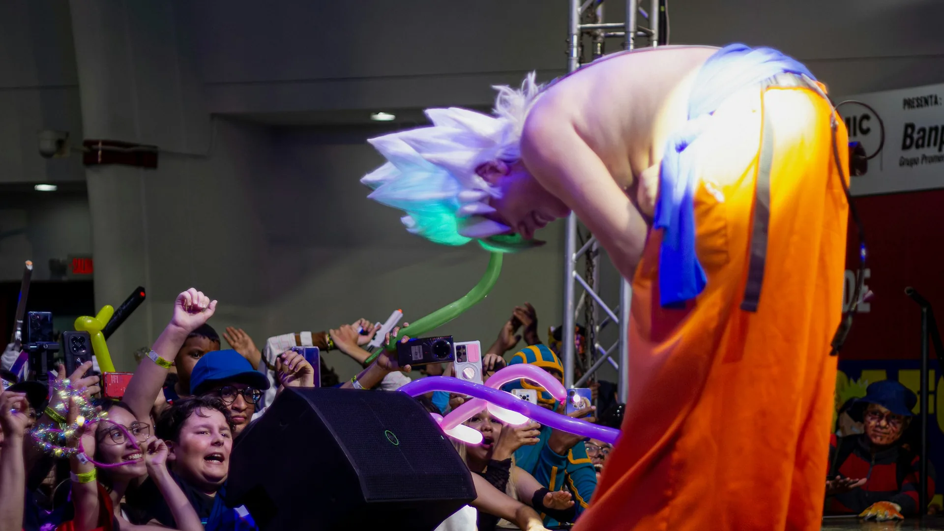 A glamorous cabaret performer in a sequinned costume and feathers under bright stage lights